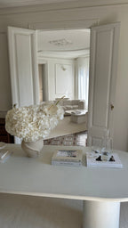 Decorative vase with flowers on a table in a stylish room.