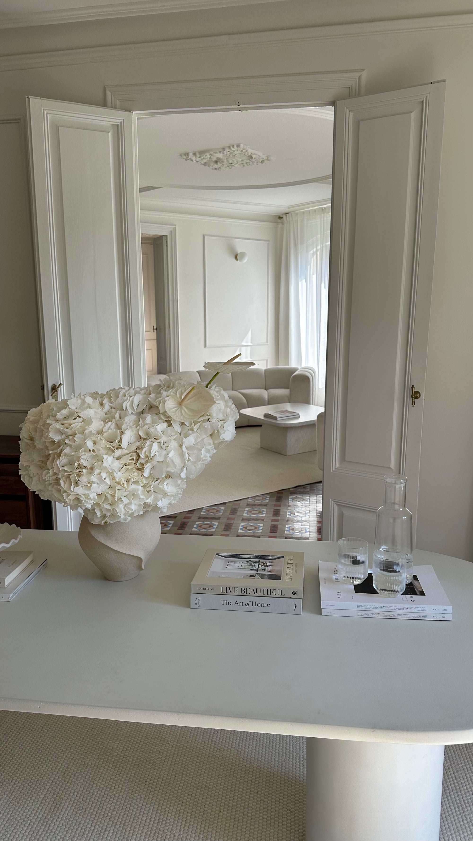 Decorative vase with flowers on a table in a stylish room.
